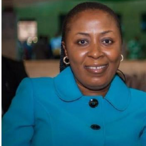 Dr Temitope Kayode sitting at a table, wearing a blue coat.