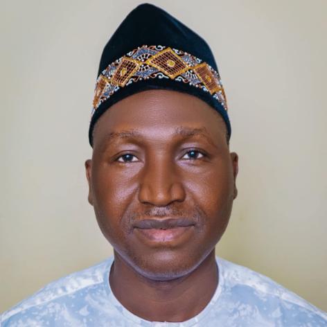 Joshua Sanga standing in front of a pale wall.