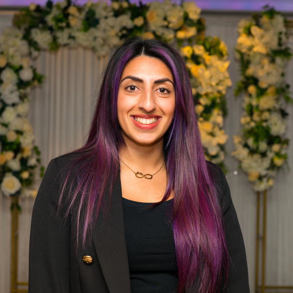 Rupinder Sandhu wearing a black blazer and shirt.