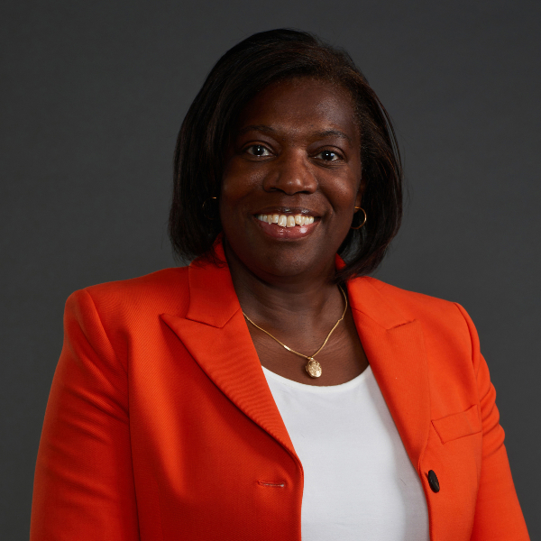 Photograph of Sandra Wallace wearing an orange blazer.