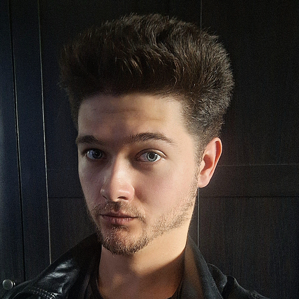 Toby Crabbe in a black studio wearing a leather jacket.