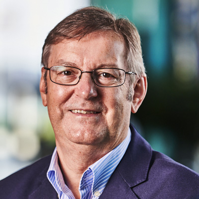 Profile photo of University of Wolverhampton alum Clive Hickman. Clive is smiling and wearing glasses and a striped white and blue shirt with a navy suit jacket.