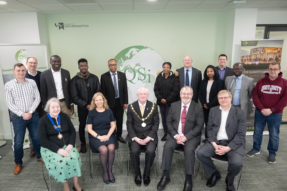 Group of representatives from QSI seated shot for official room opening