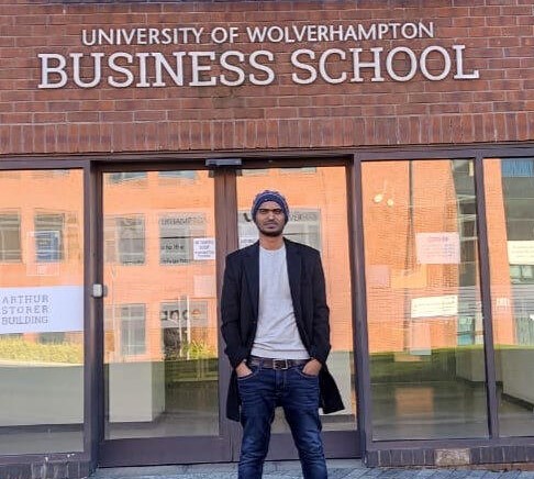 Student standing outside the University's Business School