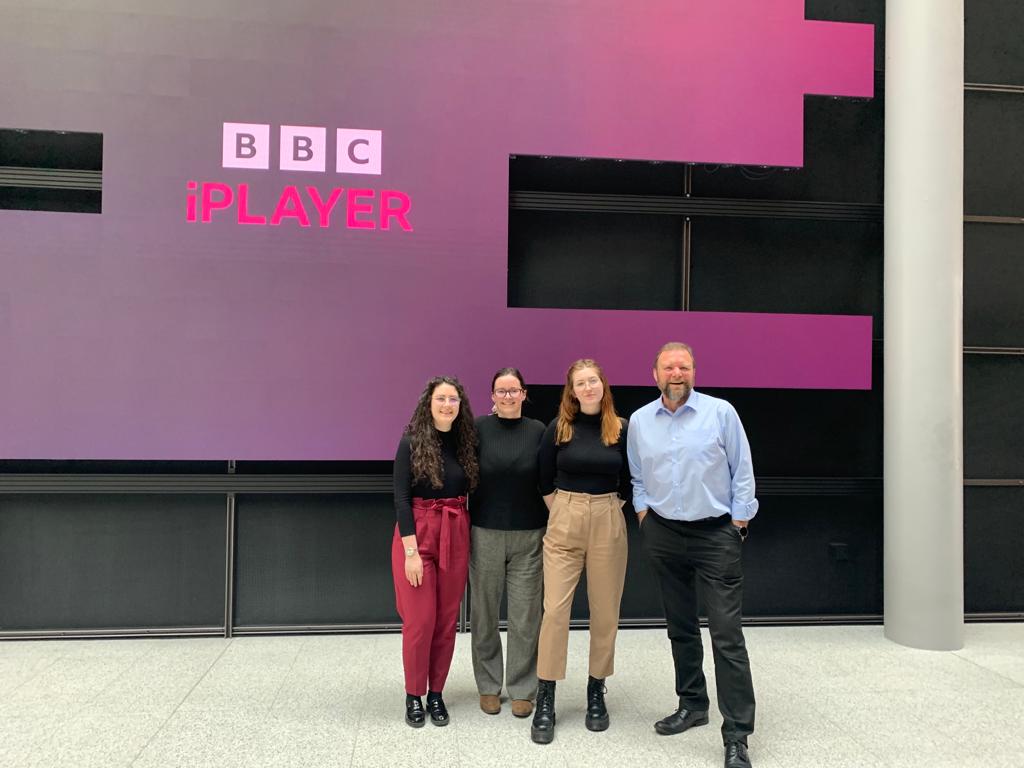 Students standing with deaf interpreter outside BBC Wales Office