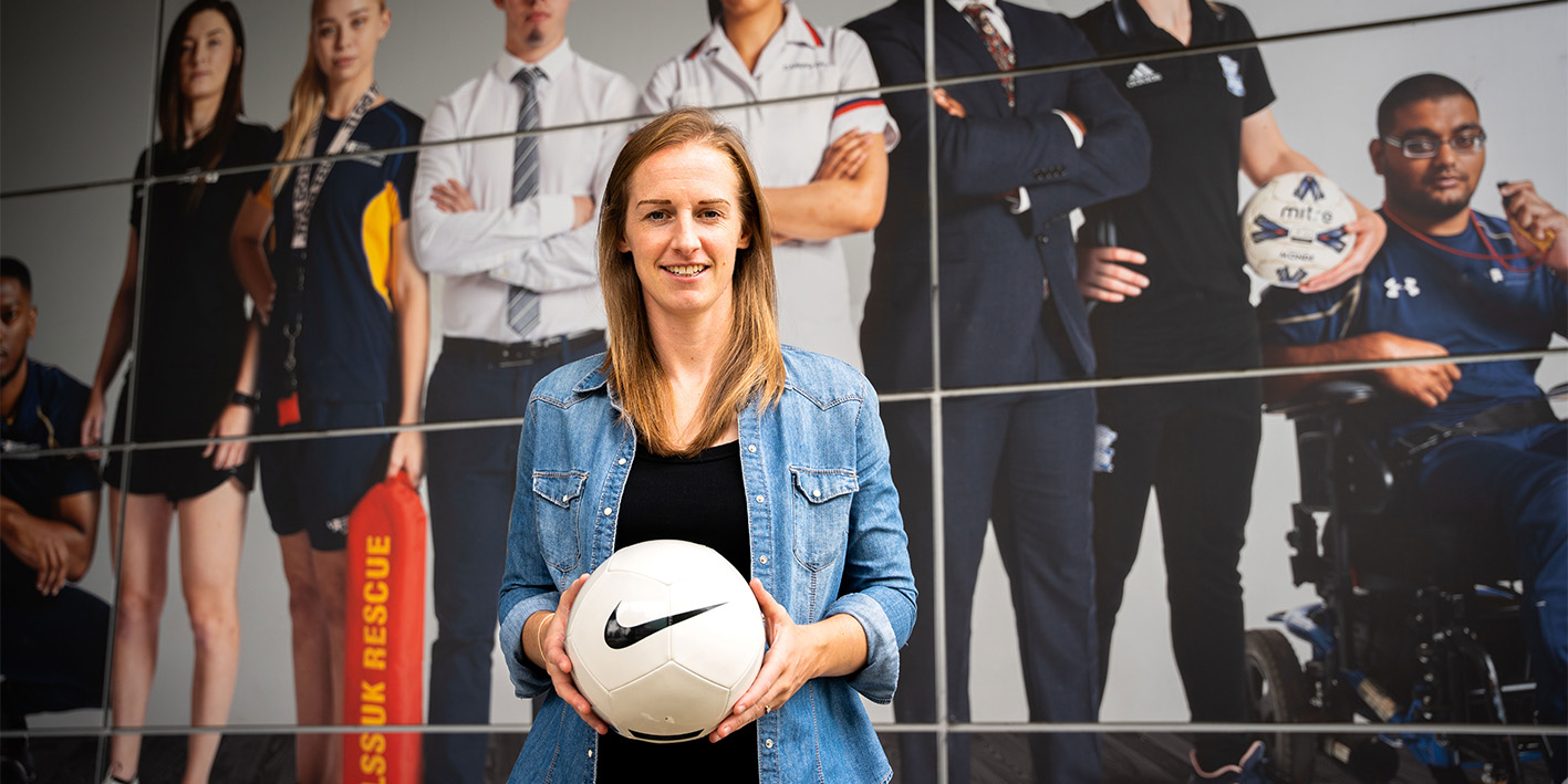 Kerys Harrop former Lioness holding a football in front of WLV Sport centre