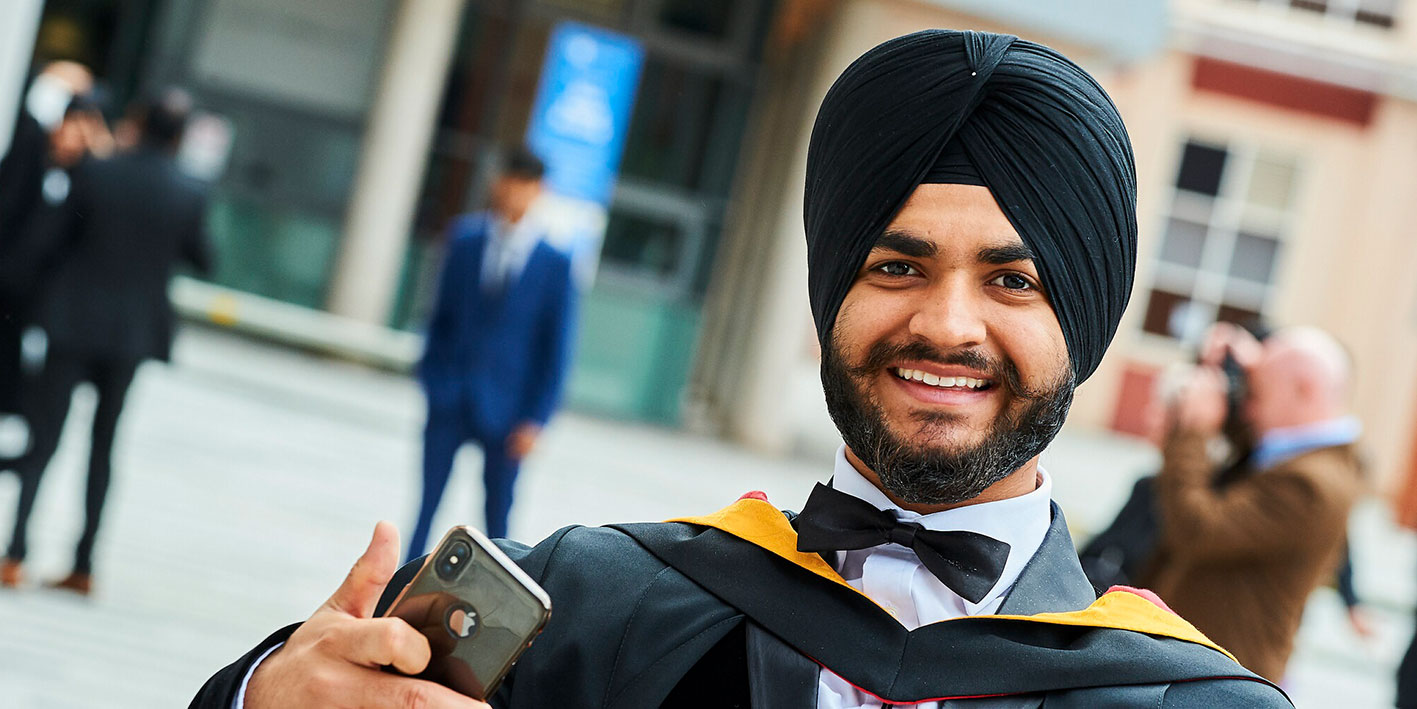 An image of a graduate smiling at the camera