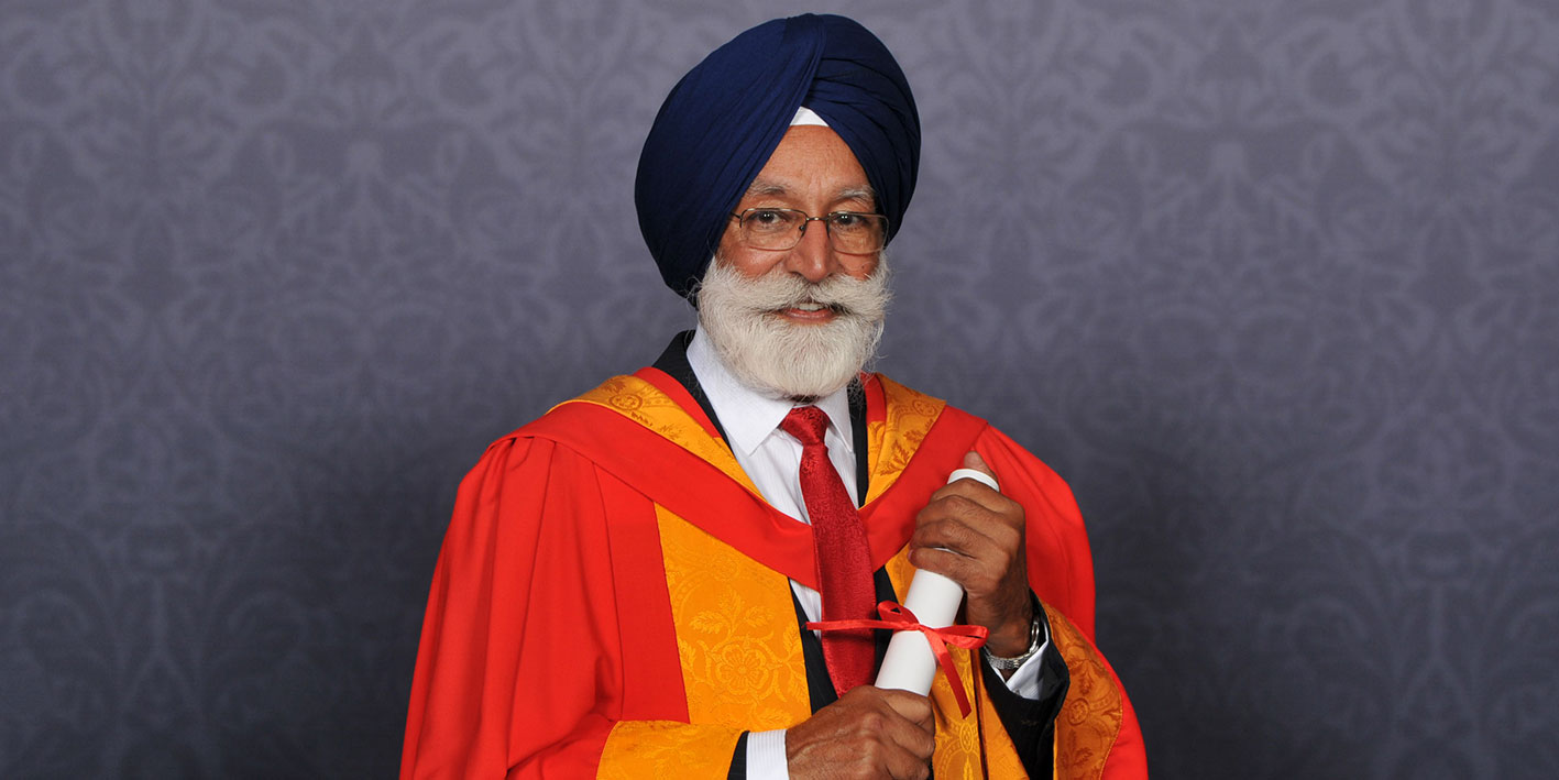 Portrait of Honorary Graduate Avtar Singh holding his Honorary Award