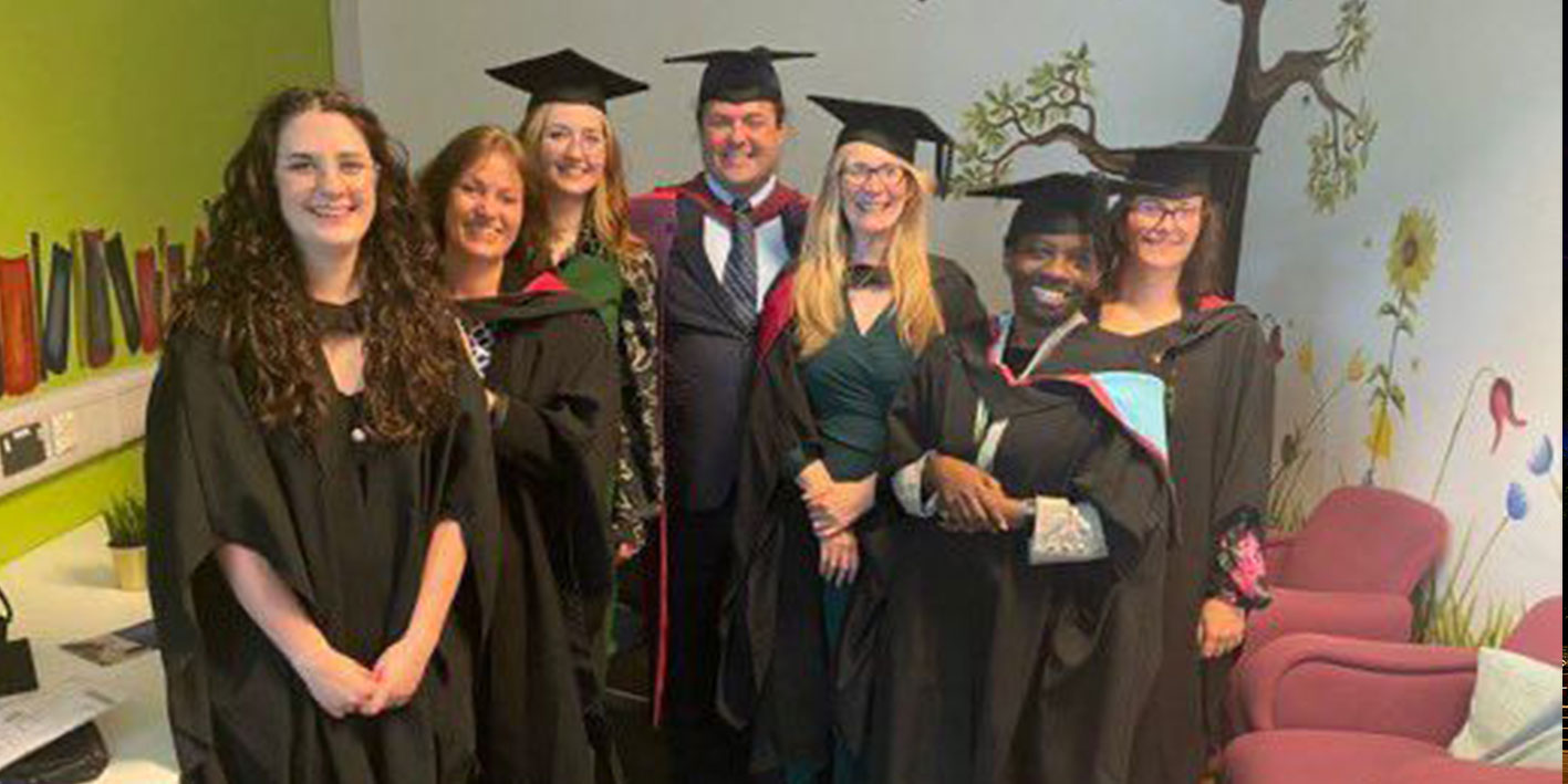 A group of alumni in caps and gowns