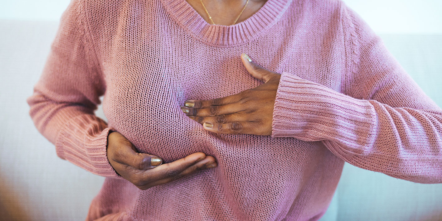 A woman pictured checking her breast for cancer