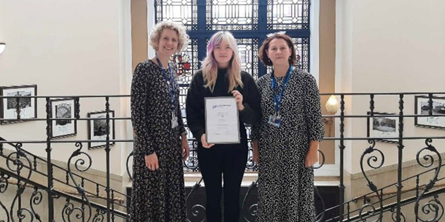 Student Alisha holding up her certificate award