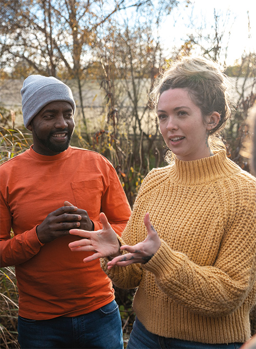 photograph of a man and women in the countryside talking expressively