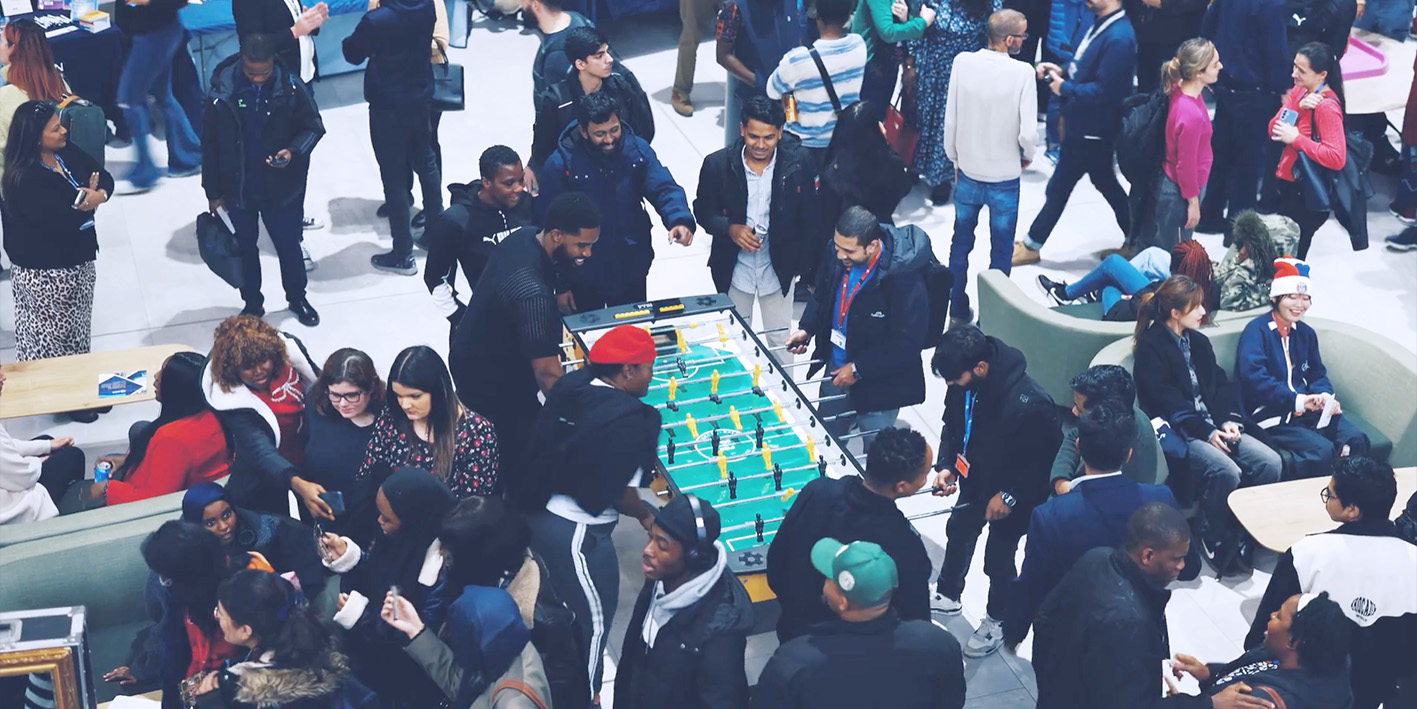 photo of large group of students having fun play table football taken from above