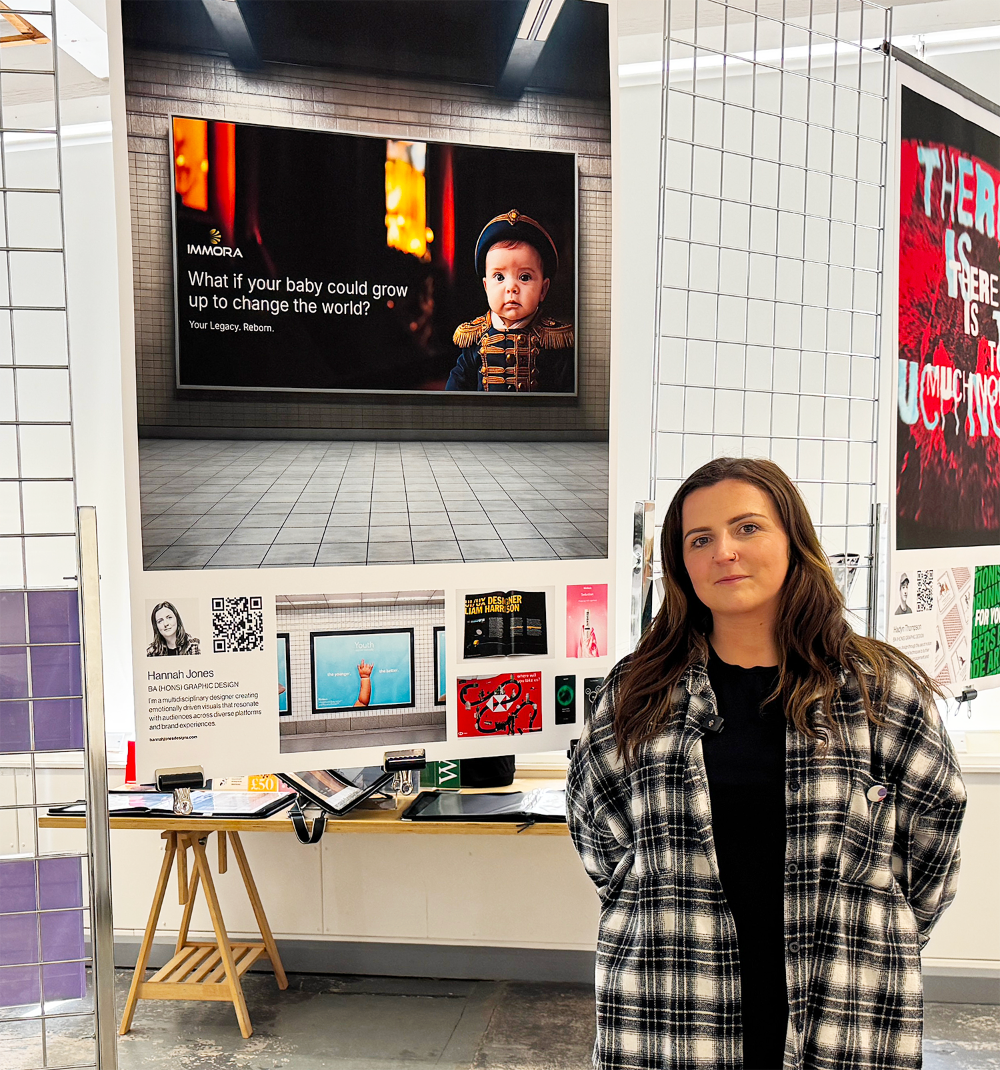 Graphic Design student Hannah Jones stands next to degree show work