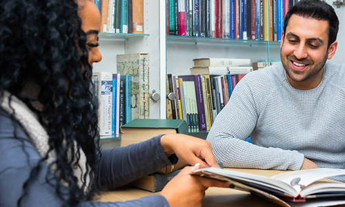 students in library looking at book
