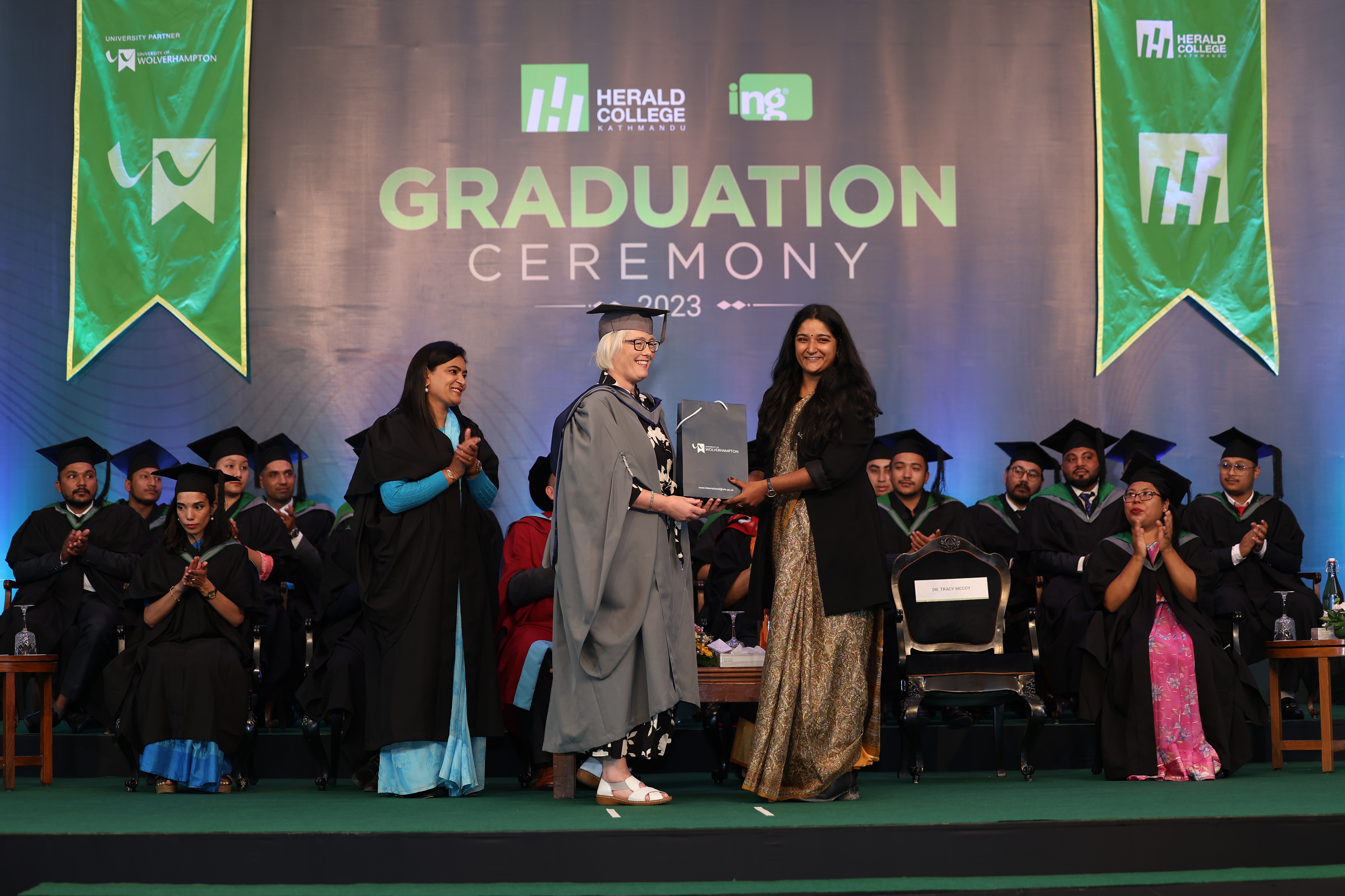 Graduating student on stage accepting her Lord Paul Enterprise Award