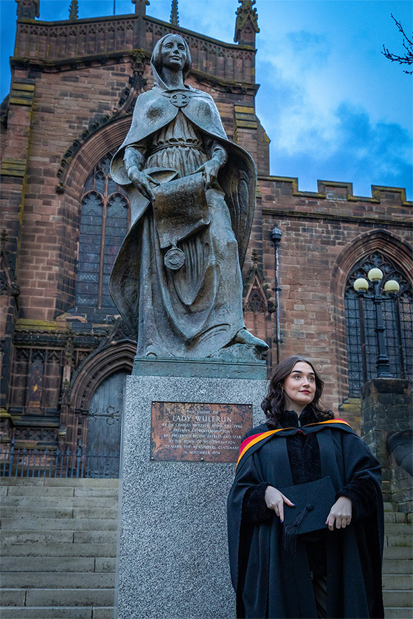 Graduate in front of Lady Wulfruna statue