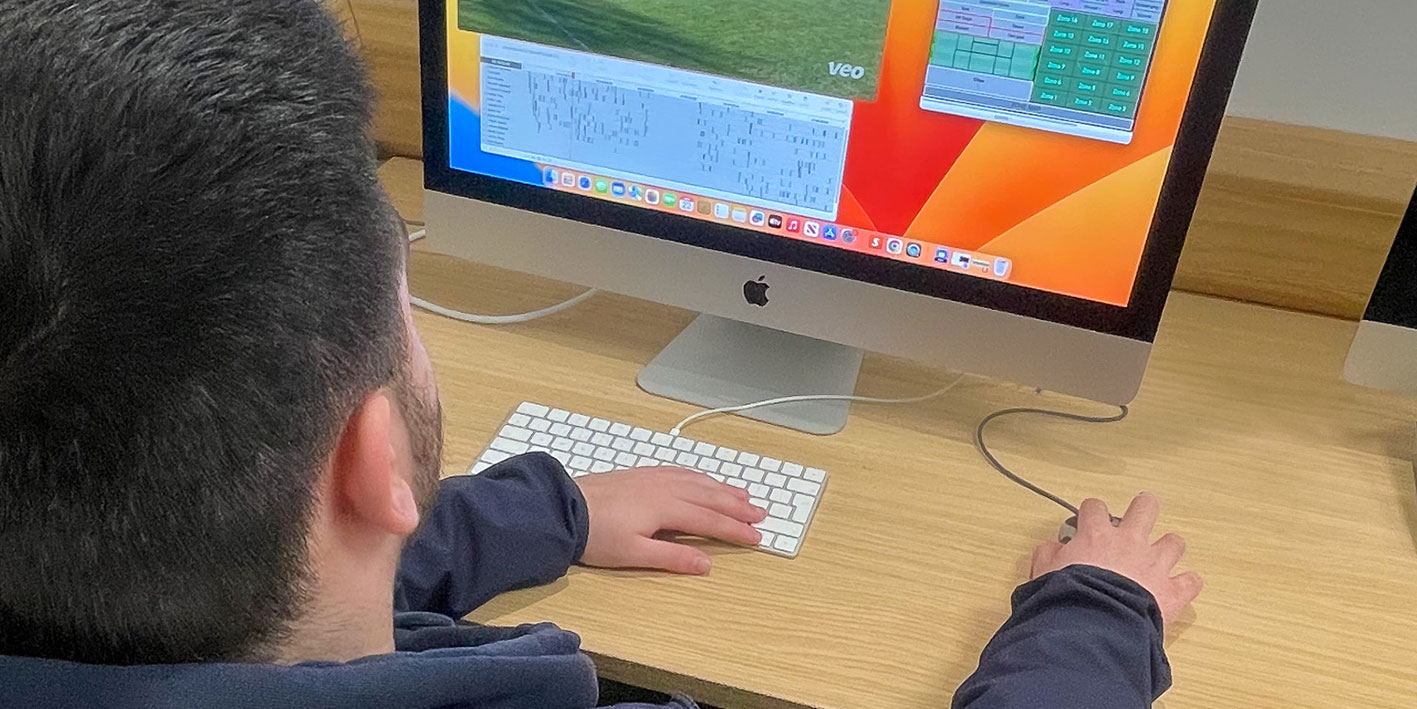 A sports student back of the head using the Hudl performance analysis software on his computer screen