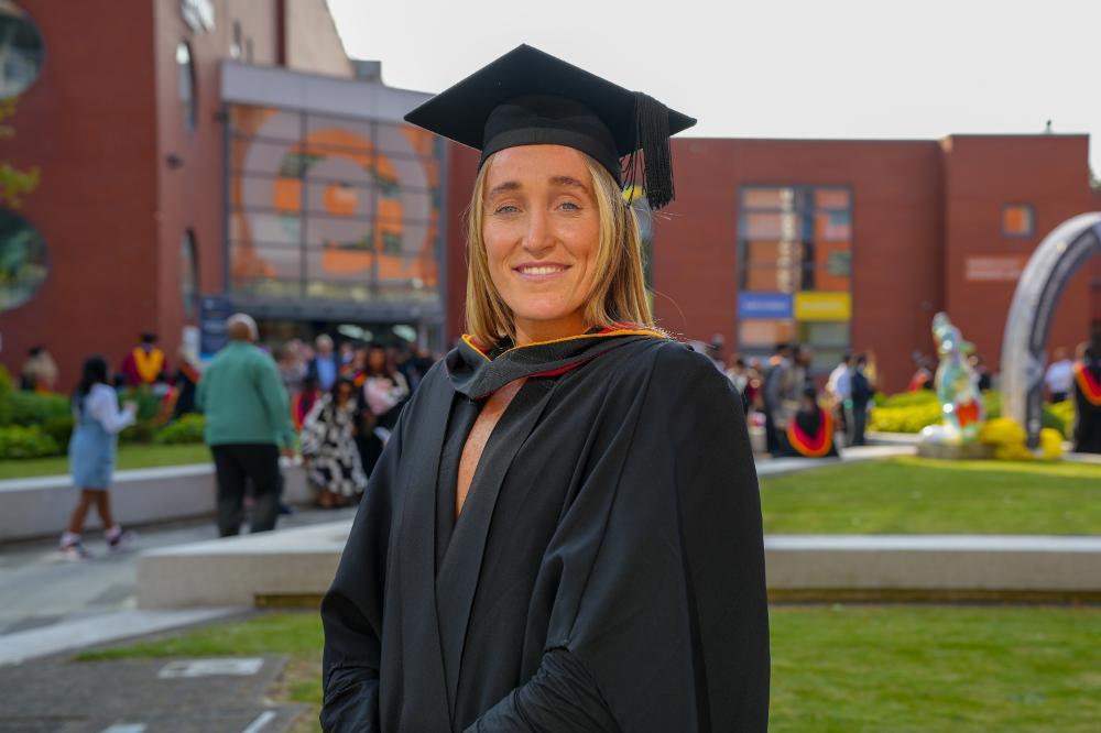 Portrait of Lucy Renshall in her cap and gown after graduating