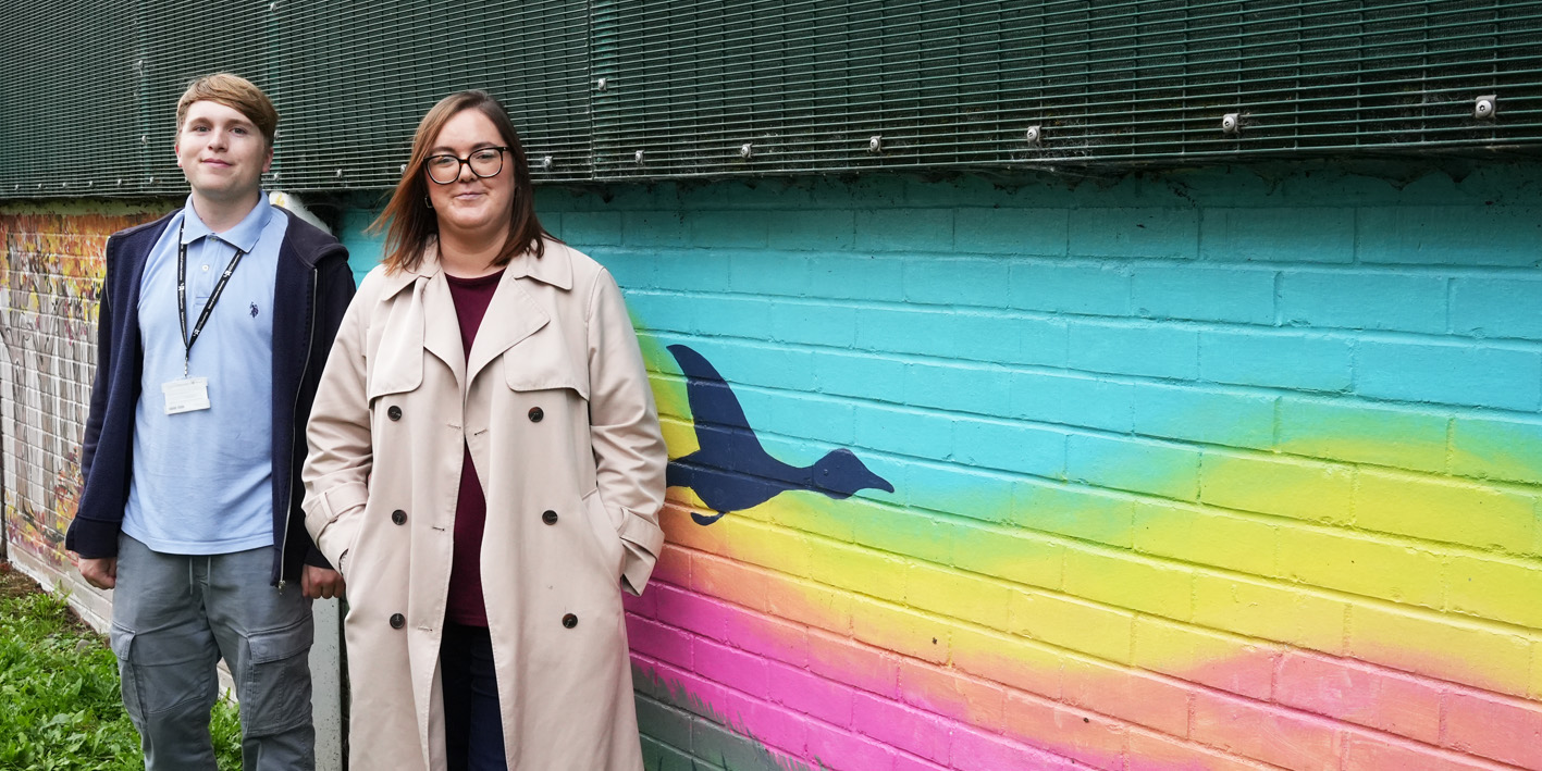 Illustration students Nathan and Laura in front of mural painted at St Georges Hospital