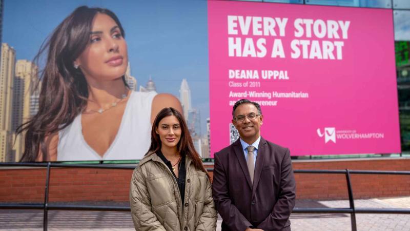 Deana and Ebrahim are stood in front of Deana's campaign image at the front of the University
