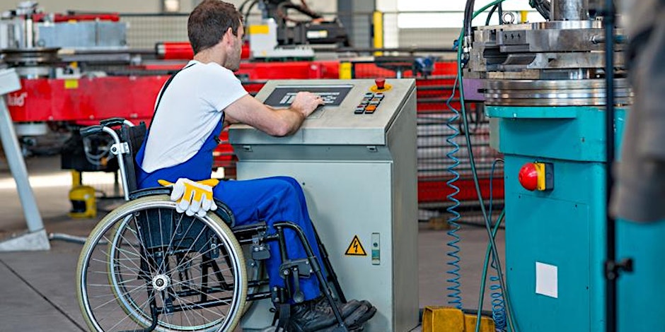 man in a wheelchair at work in an industrial setting