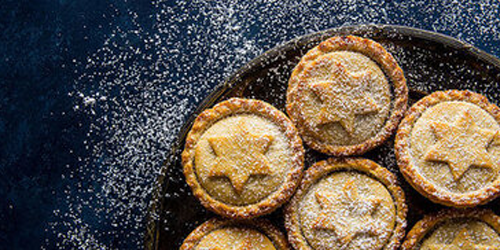 mince pies on a table dusted with icing