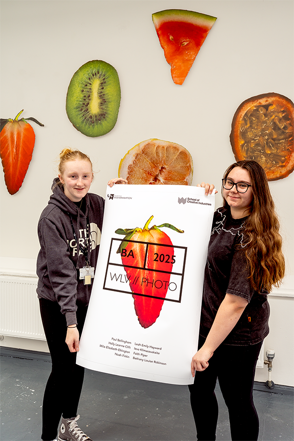 Photography students hold up Degree Show poster