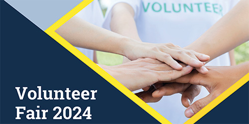 Volunteer Fair 2024 graphic: a group of people in a circle wearing volunteering shirts putting hands of top of each other