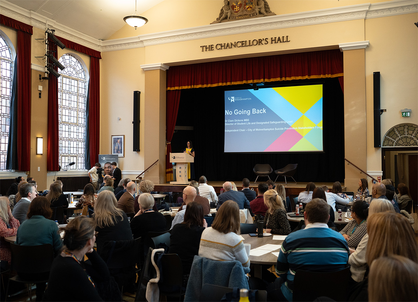 Mental Health Conference 2025 view from the audience looking on to the stage where Dr Clare Dickens presents