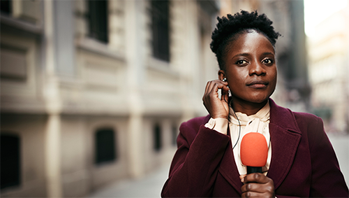 Journalist in street holding a microphone