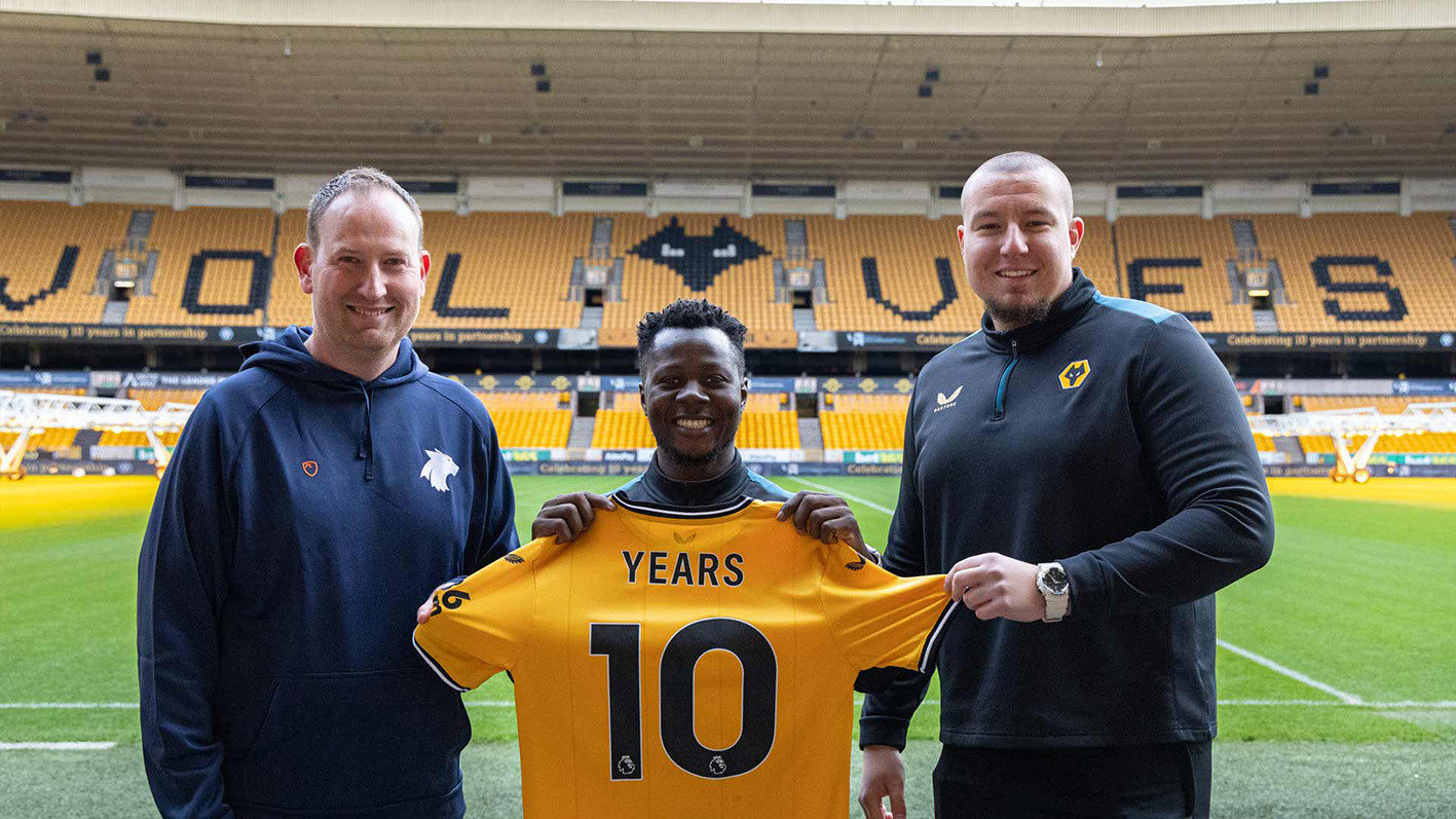 Group photograph at Molineux stadium with commemorative 10 year shirt