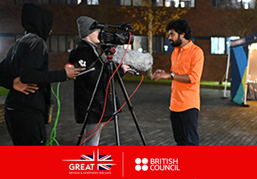 Photograph of an international student being filmed with professional video equipment at an night time event on campus