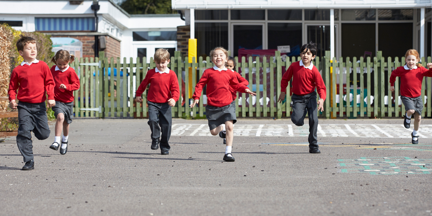 Elementary School Pupils Running In Playground Towards Camera
