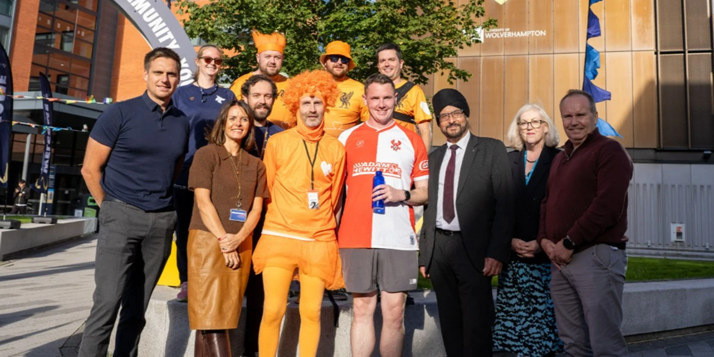 charity runner Shaun McEntee poses with MP Warinder Juss and university staff in City courtyard welcoming Shaun as he completed the first leg of his 5 day 100 mile challenge