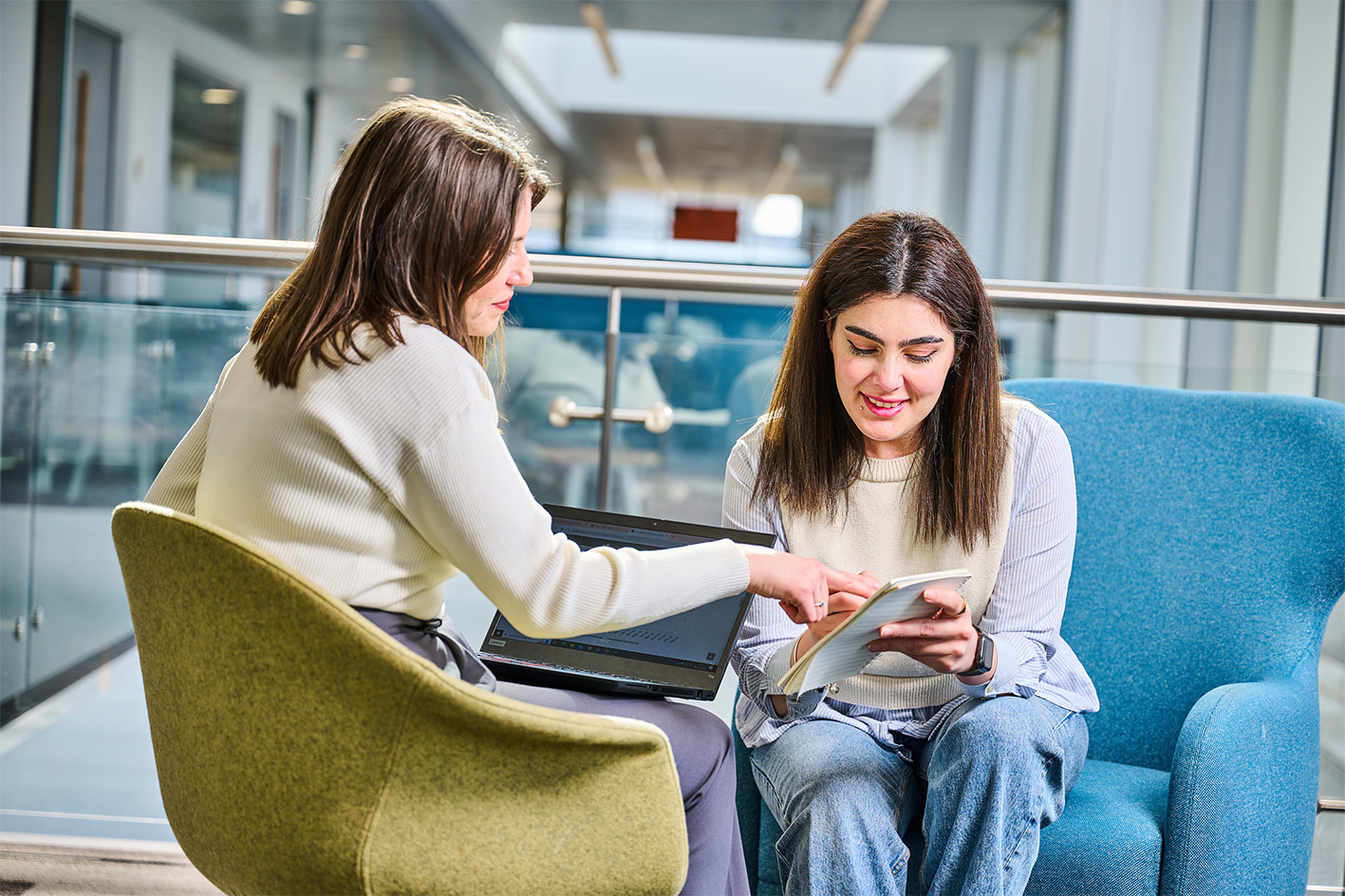 Two women in the Business School working with a laptop and paperwork