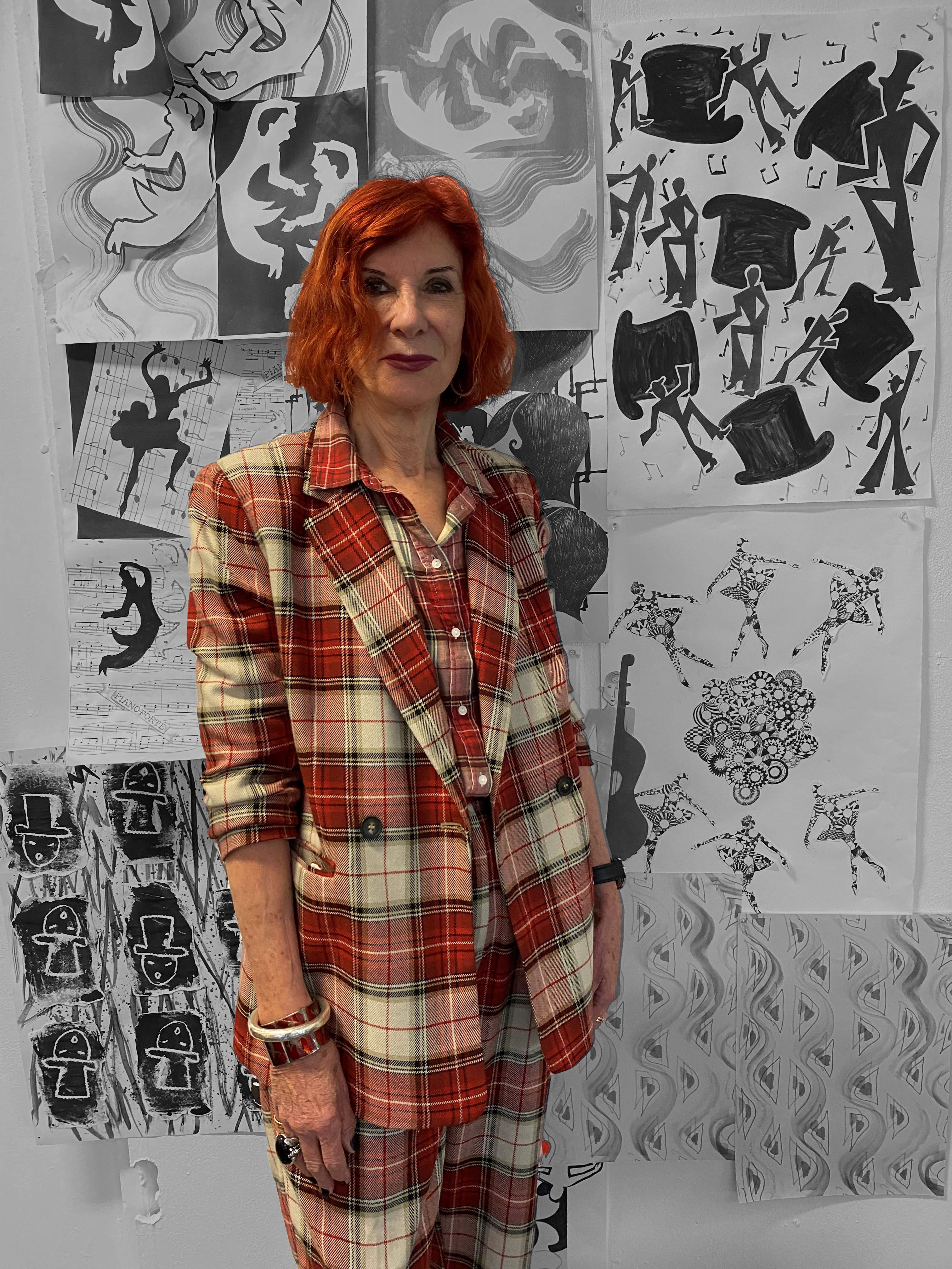 Janet MacDougall in front of a wall of artwork