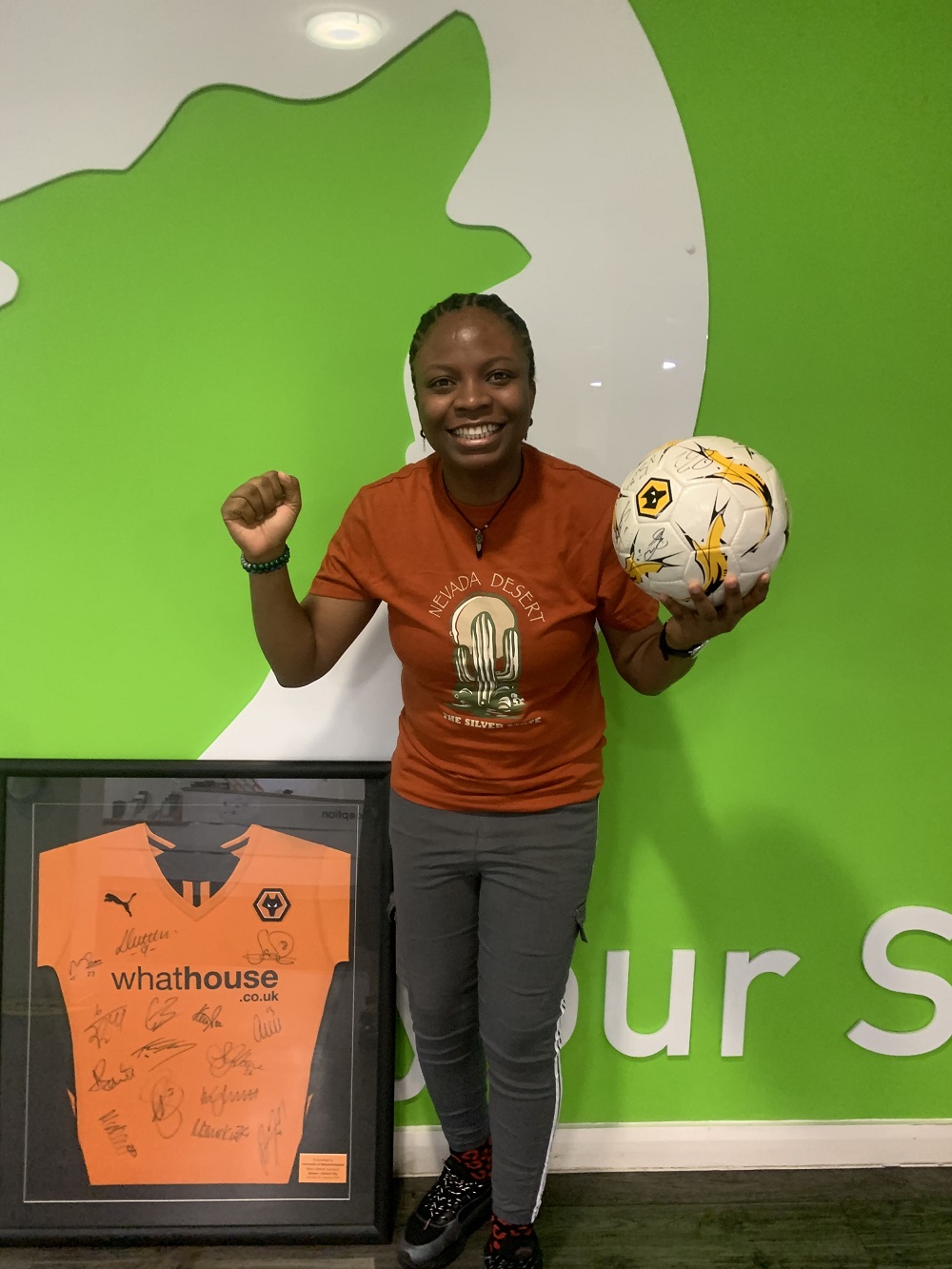 Students Union President holding a Wolves signed football ready for auction