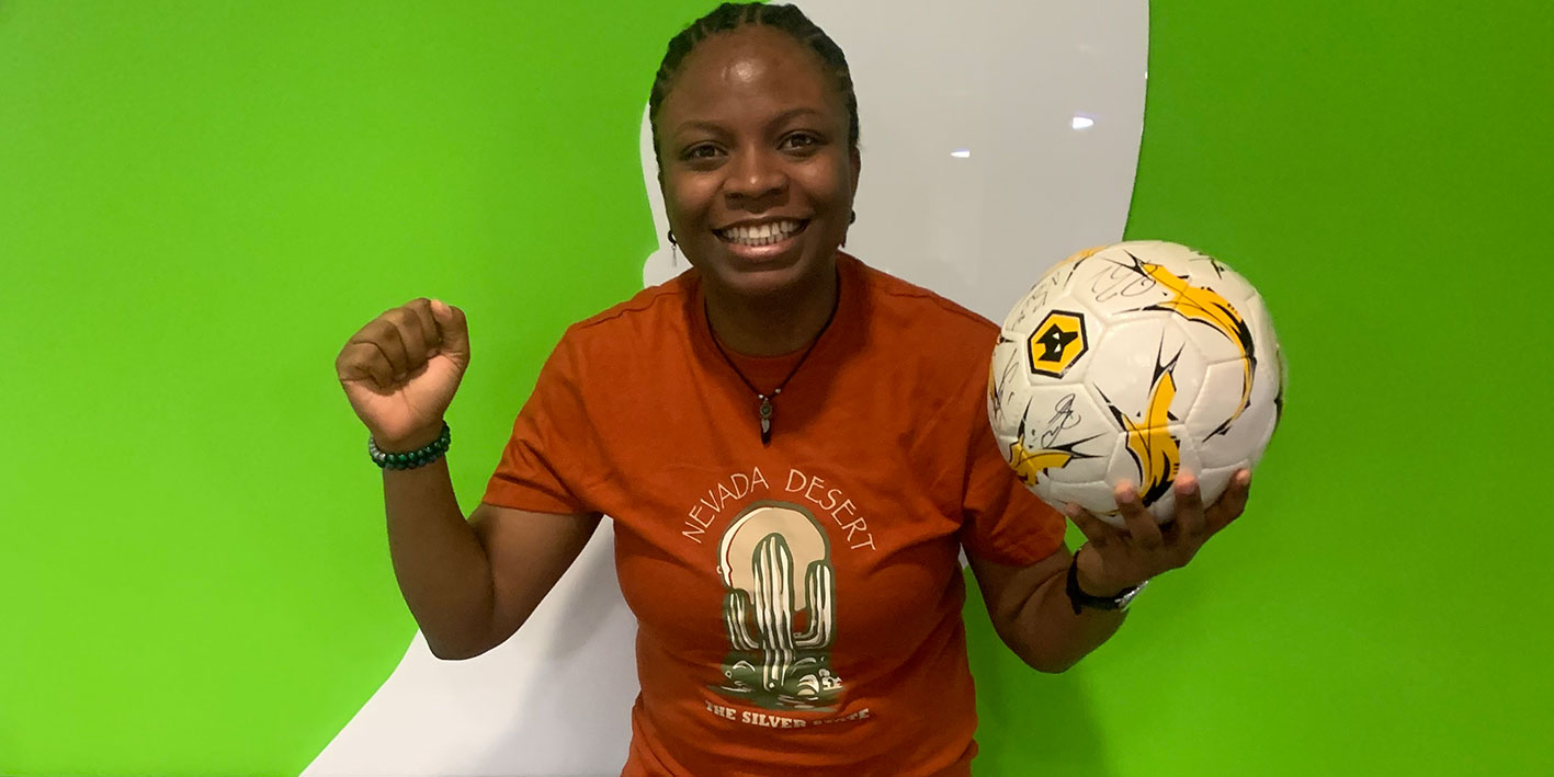 Student's Union President holding a Wolves signed football ready for auction