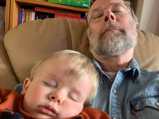 David Matheson in his home, sitting on a sofa with his eyes closed