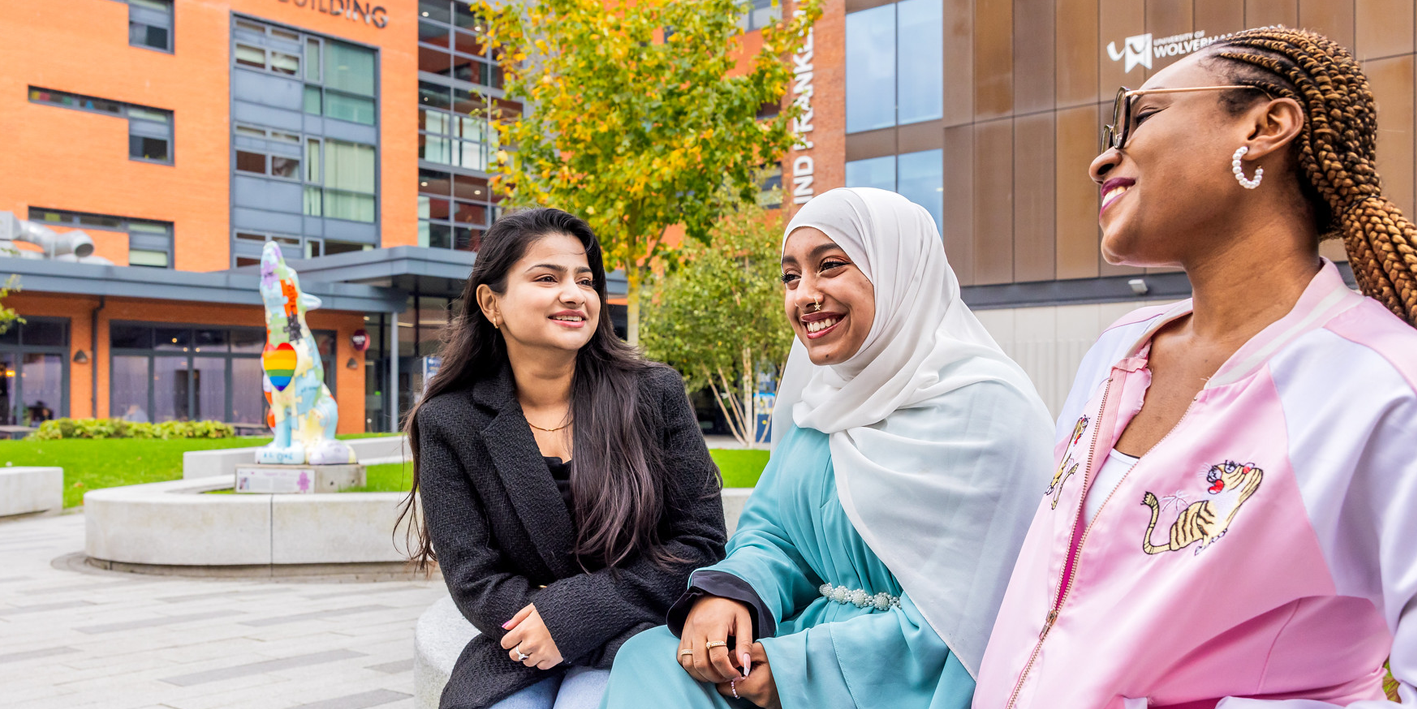a group of global majority students in the courtyard