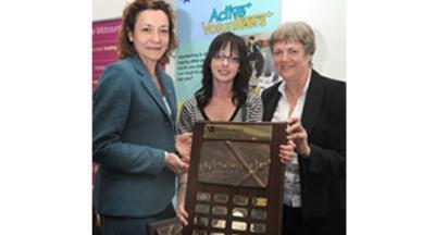 Trish Poole from Midcounties Co-operative, sponsors of the award, presents the trophy to wining student Jodie McCaughan, with Active Volunteers Co-ordinator Pat Green looking on.