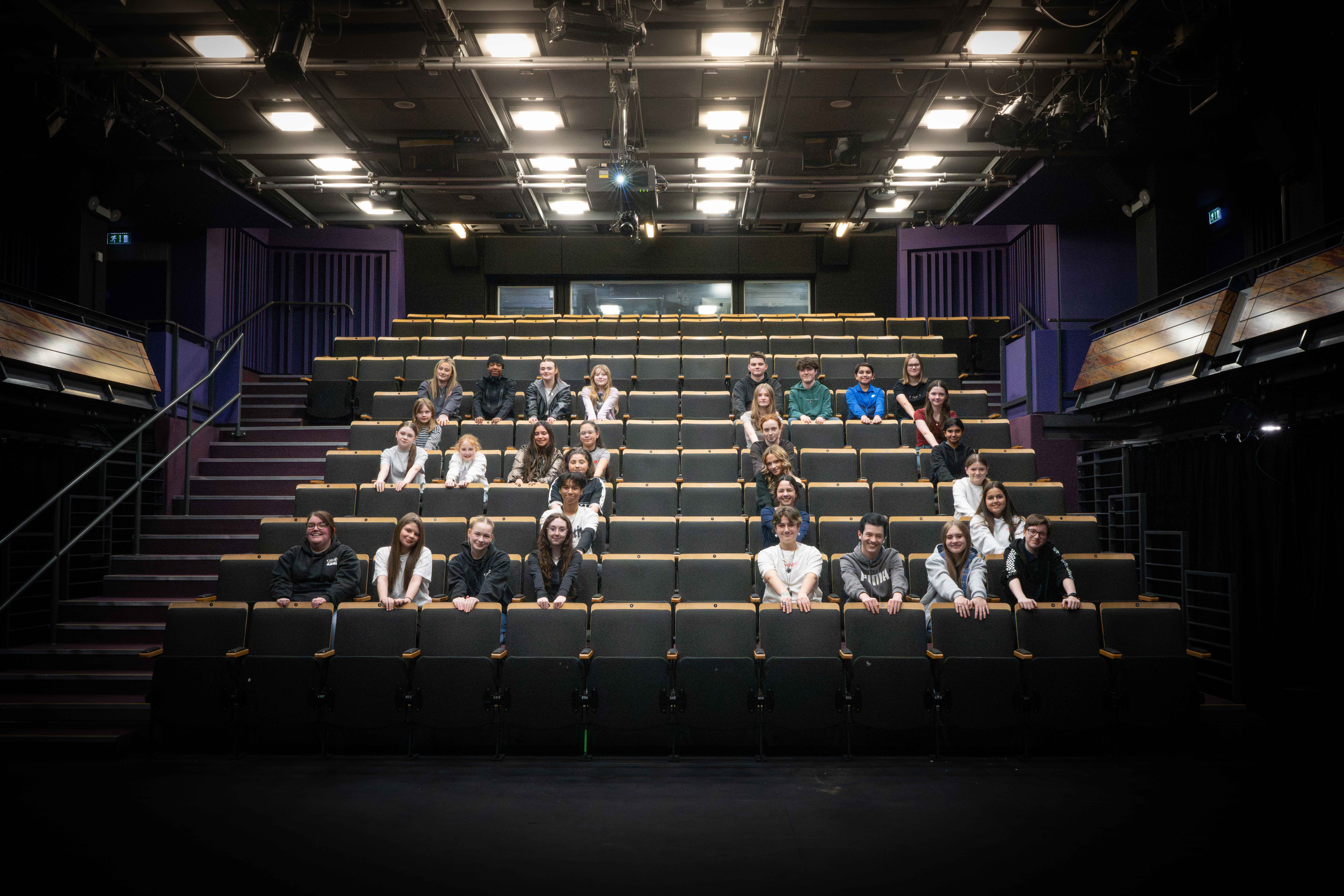 Members of the youth theatre seated in the theatre in the shape of a 50 to celebrate the golden anniversary