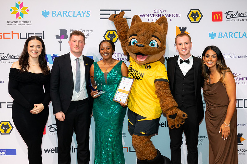 Rising Star – Postgraduate Winner Ify Nwiwu receives her award with 'Wolfie' from Wolverhampton Wanderers and other guests
