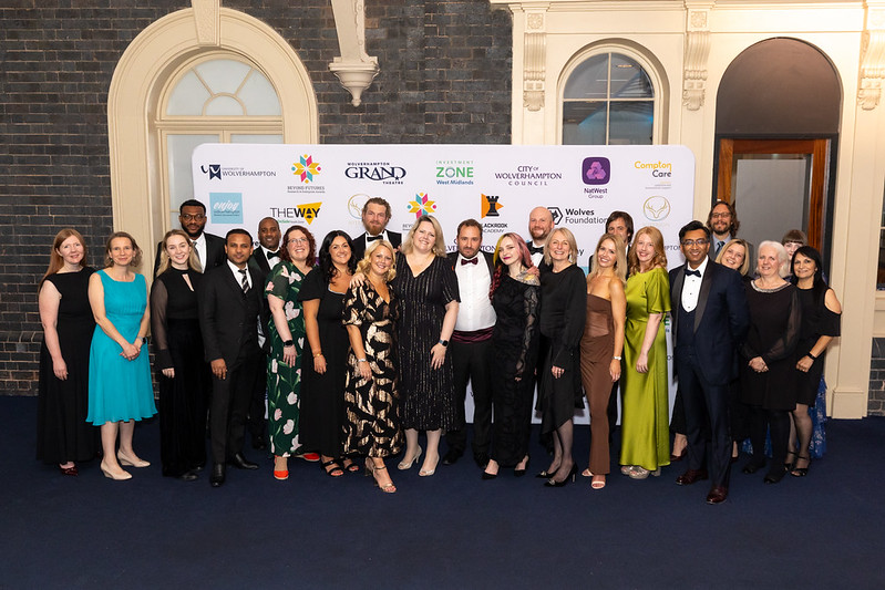 Staff and academics gather together for a group shot, dressed in ball gowns and tuxedos at the awards evening