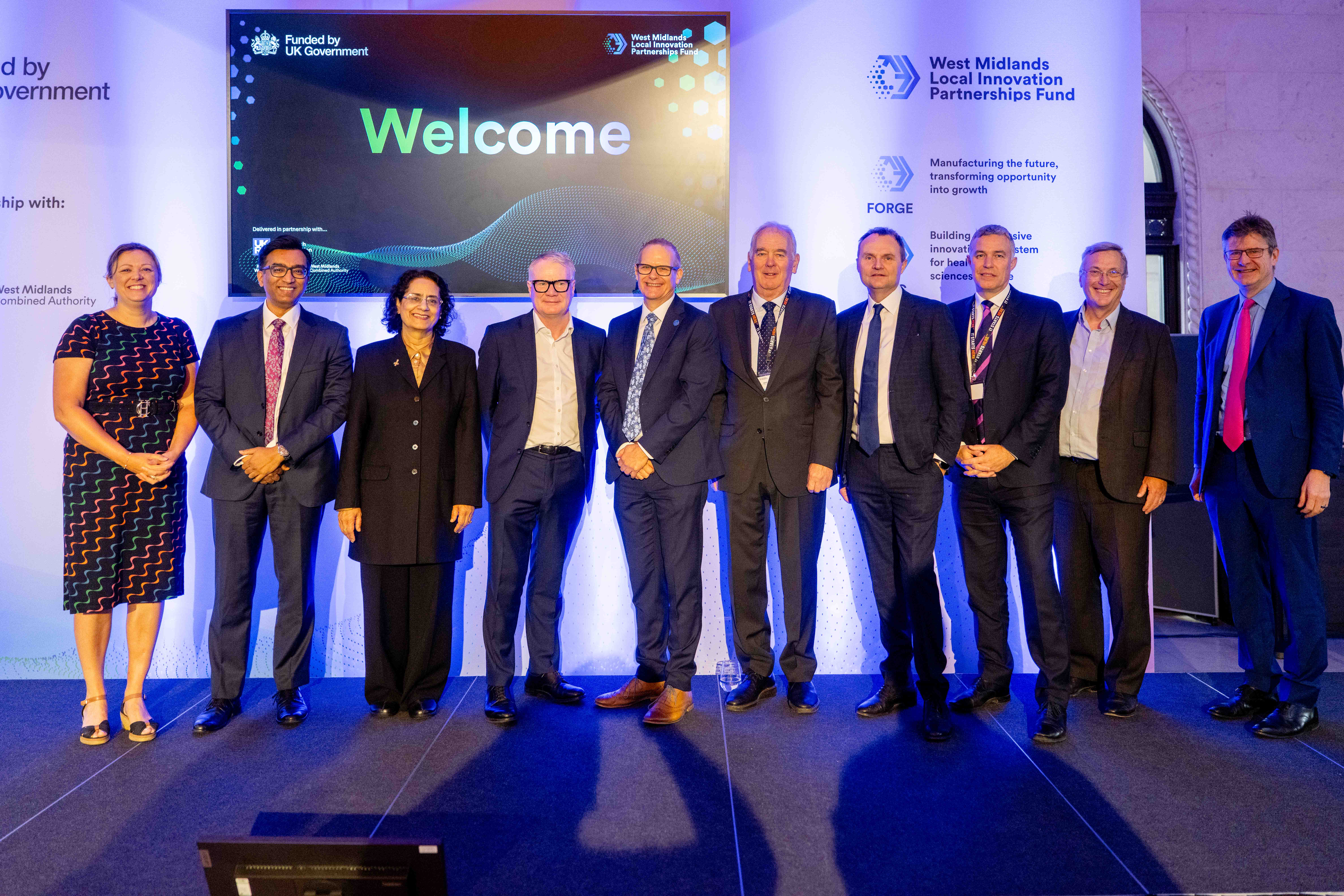 Picture by Thom Bartley and shows 10 men and women dressed in smart clothing lining up. They are representatives from West Midlands Universities.