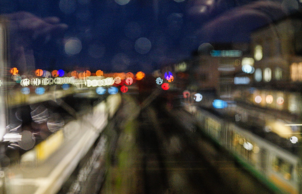 Header image of a train station at night as taken through a blurry pane of glass