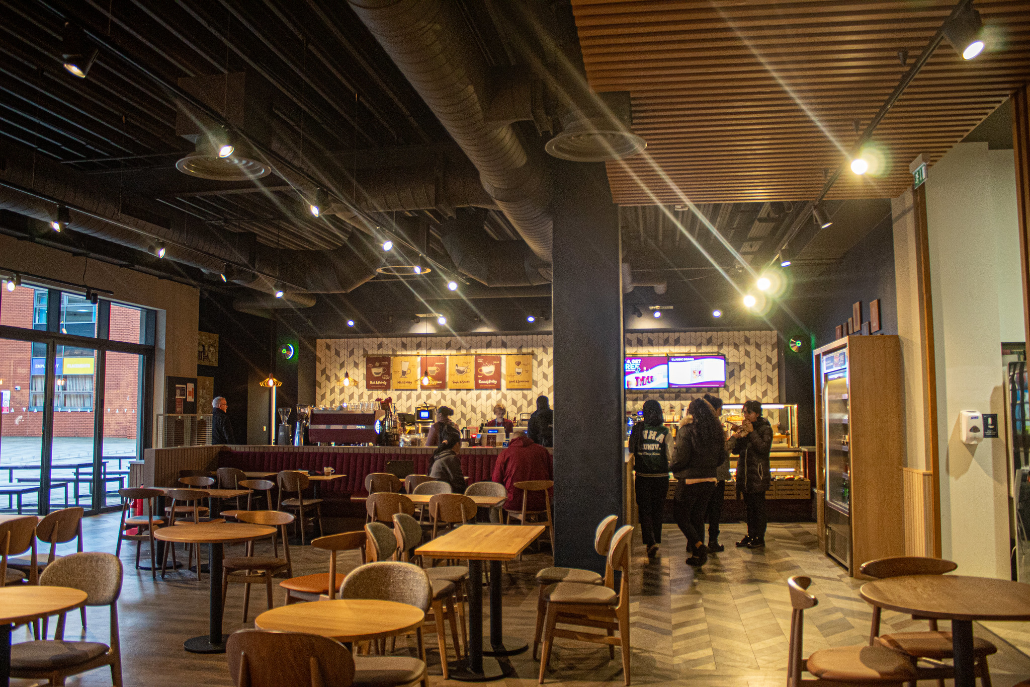 Costa Coffee in the MC building, students lining up at the counter behind rows of seating