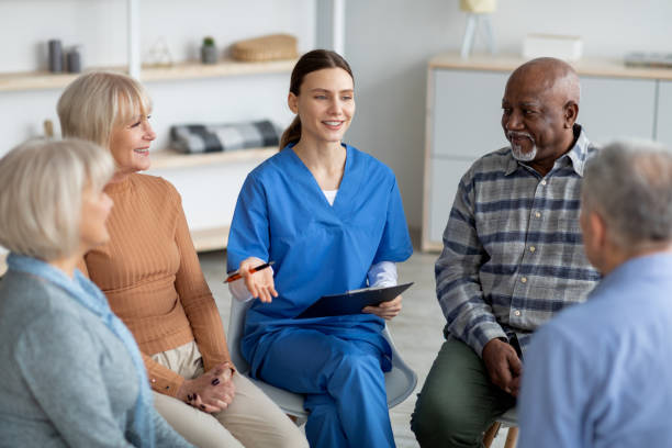 Thumbnail for the Understanding Lived Experience of Health, Illness and Healthcare research cluster, depicting a nurse addressing a group of seated patients