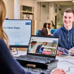 A staff member helping a student to apply